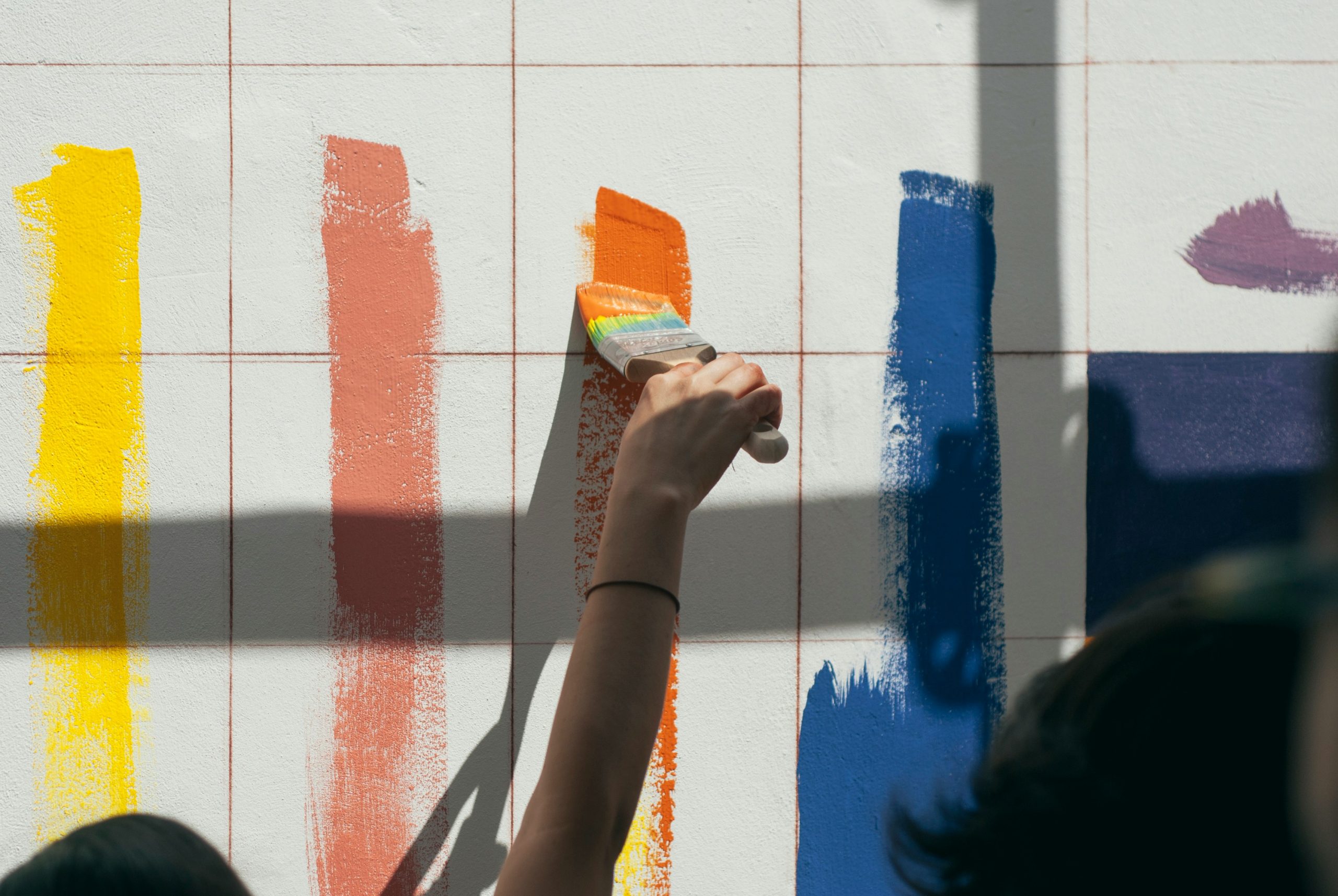 woman trying different paint colors on a wall